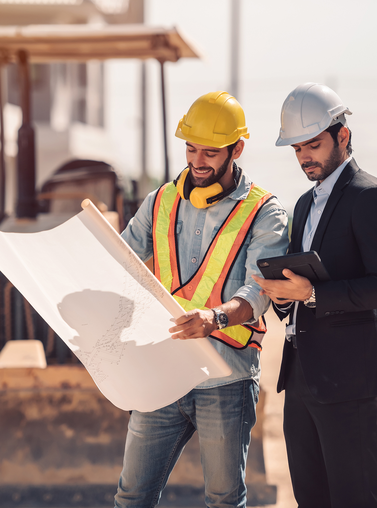 Civil engineer and construction worker manager holding digital tablet and blueprints , talking and planing about construction site.  Cooperation teamwork concept.